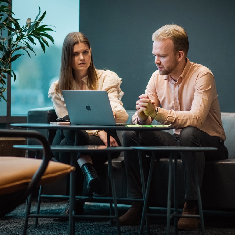 En mann og en dame sitter foran en PC