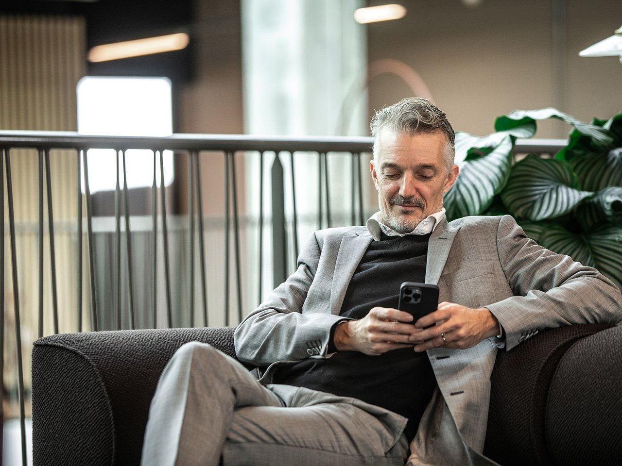 Mann sitter med selvbetjeningsløsning på mobil