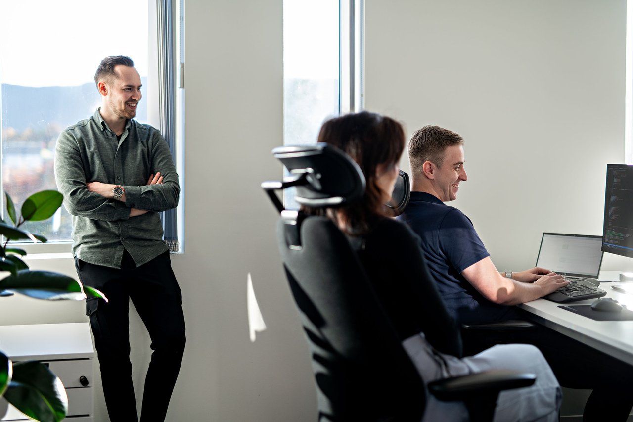 coworkers smiling and looking at pc -Fullbredde