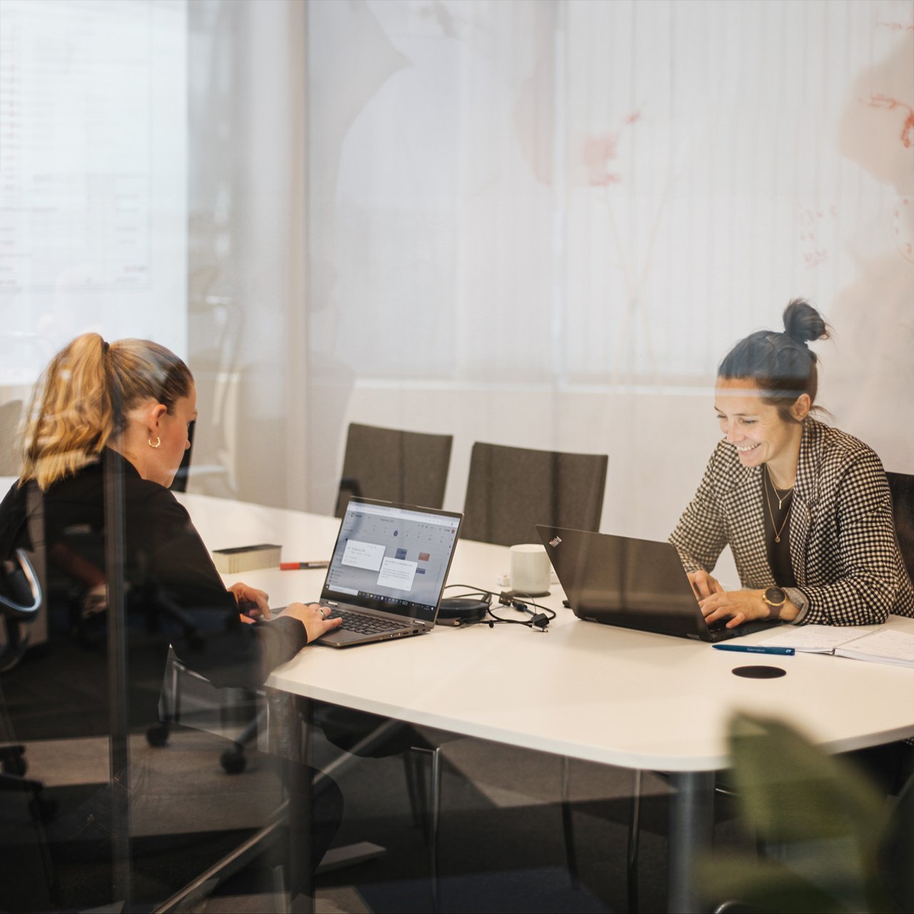 To damer sitter og jobber på et kontor