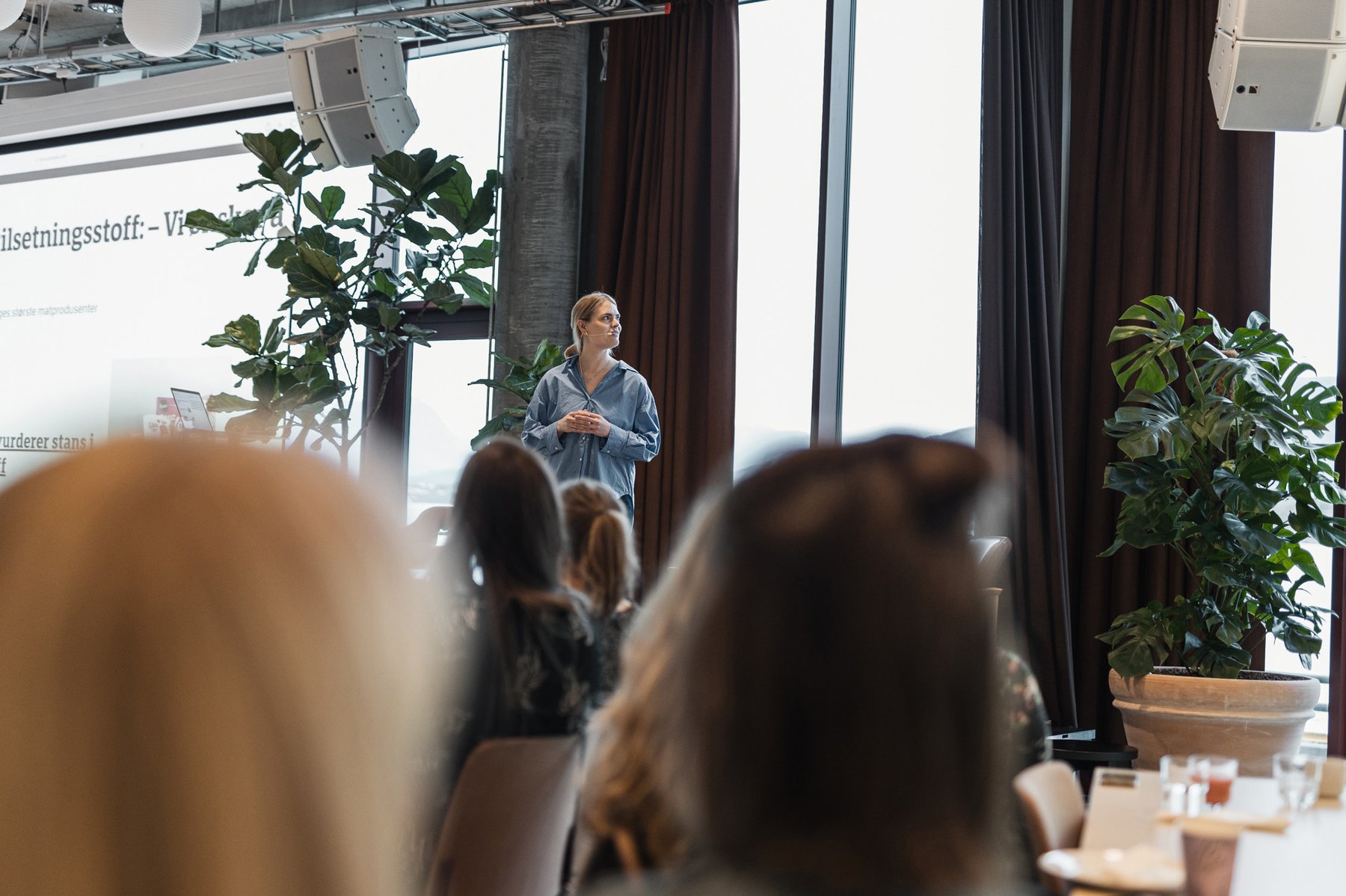 Dame som står på en scene foran publikum