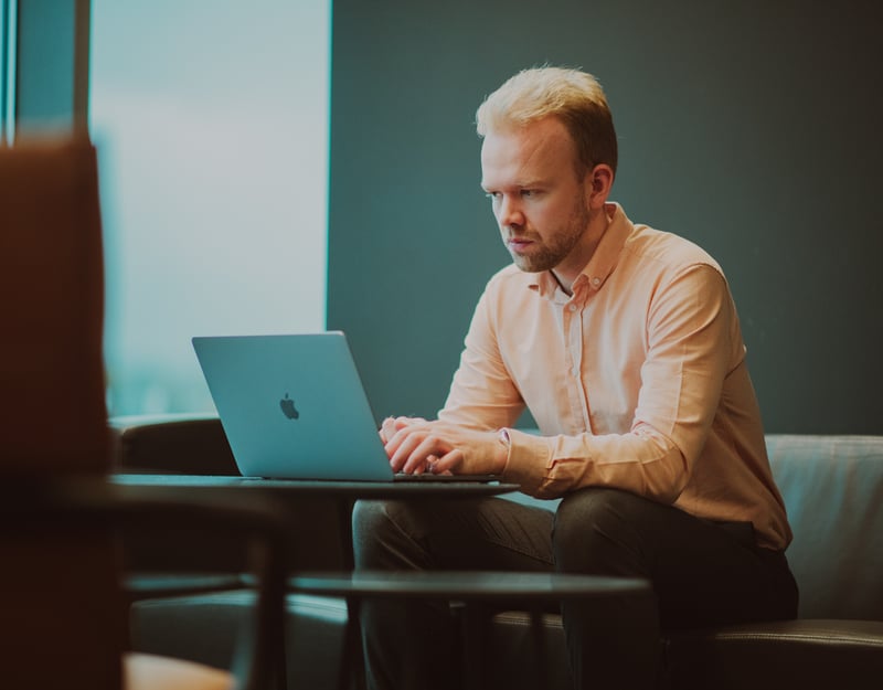 Bilde av en ung mann som sitter og jobber på en PC