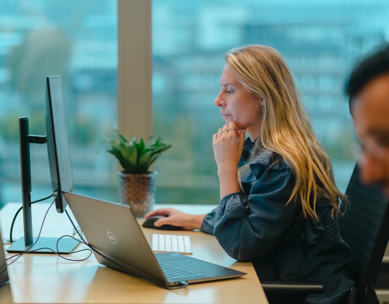 Ung dame sitter og jobber konsentrert på en PC