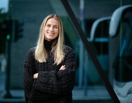 Portrettbilde av en blond dame med sort genser som ser i kamera