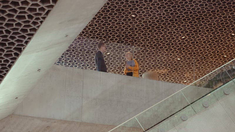 Bilde av mann og dame som står på toppen av en rulletrapp