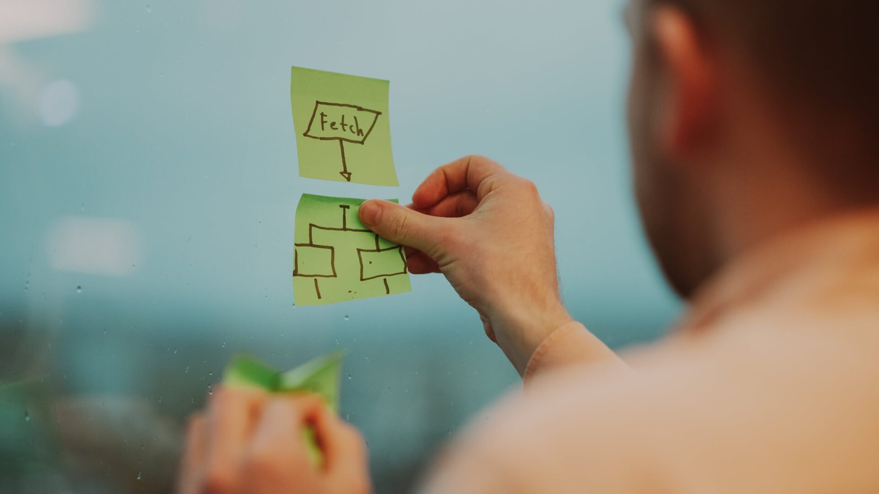 Nærbilde av en mann som henger opp postit-lapper
