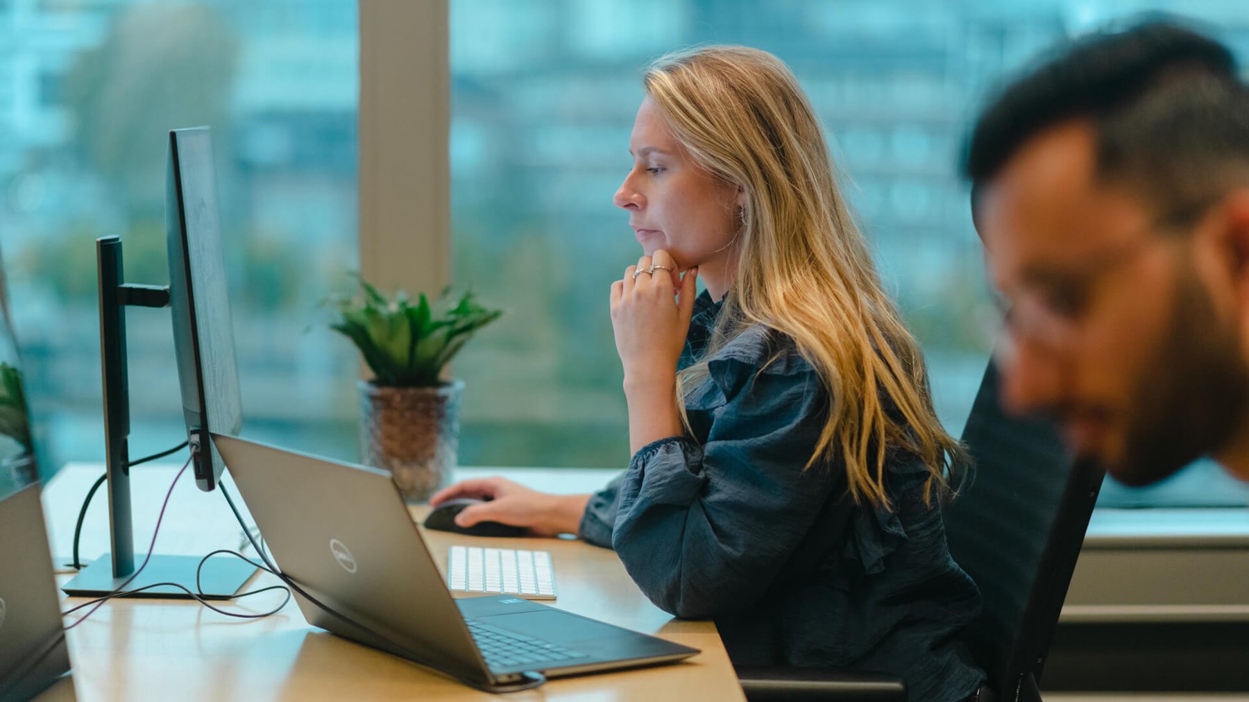 Ung dame sitter og jobber konsentrert på en PC