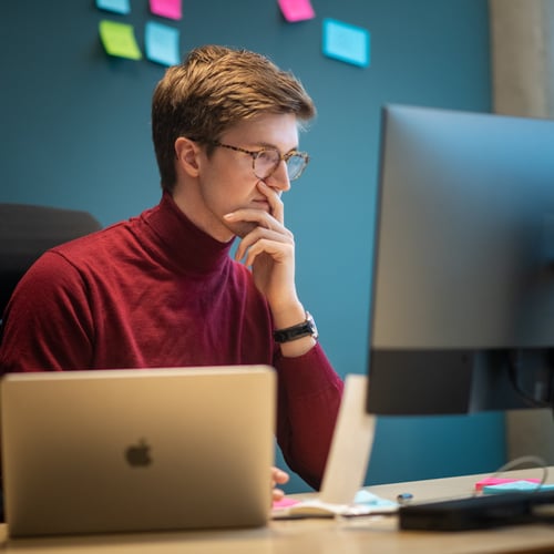 Mann jobber konsentrert foran en PC