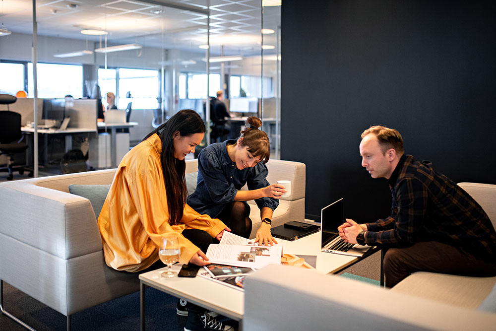 tre personer på sofaen i kontoret 