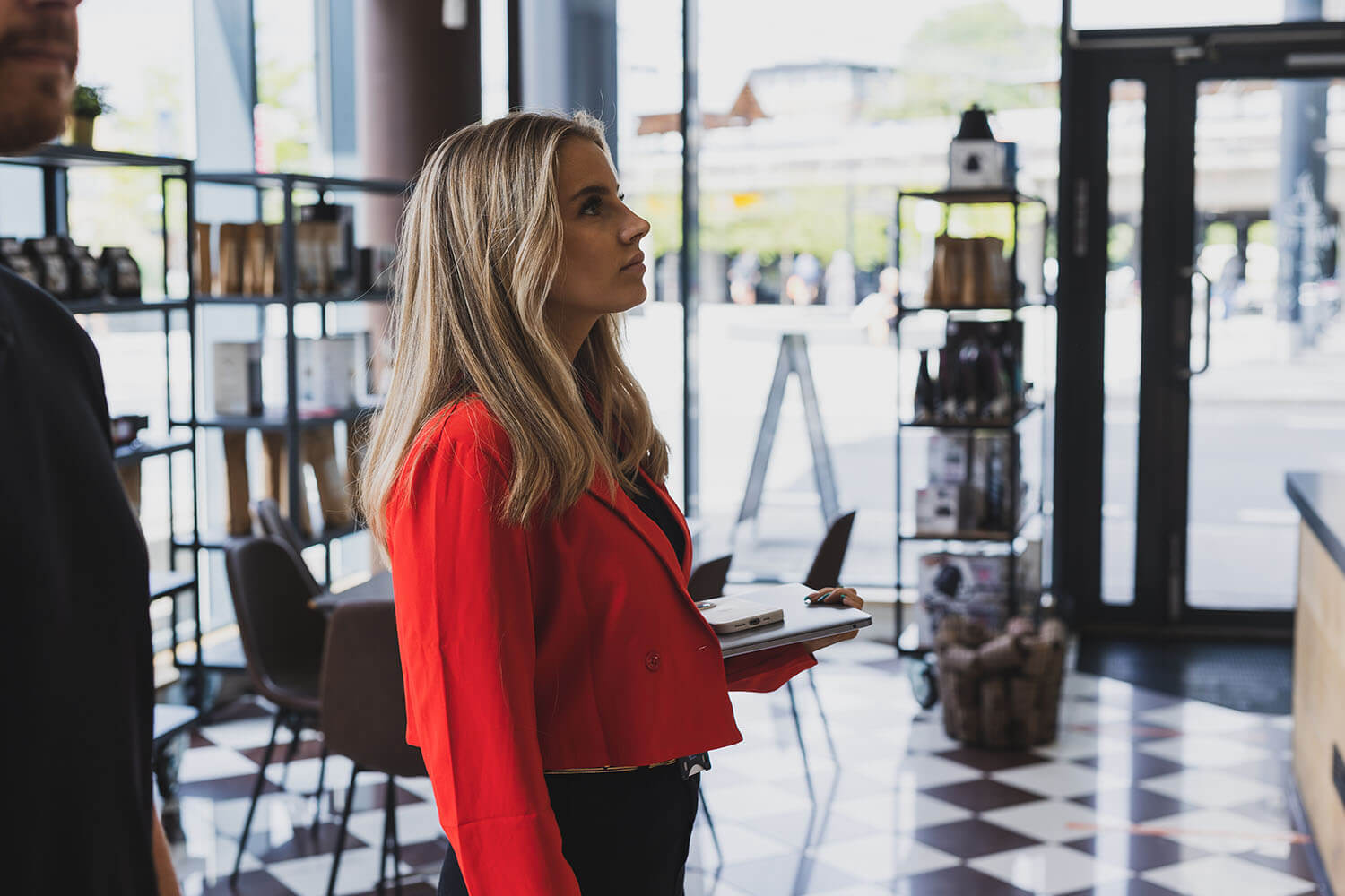 Girl with red jacket standing in a cafe